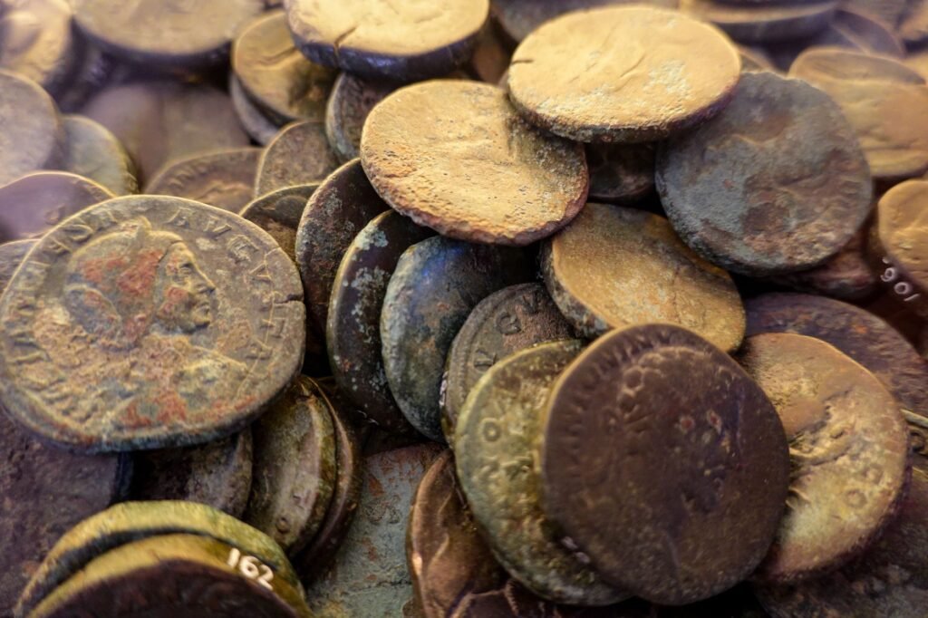 Close-up of weathered ancient Roman coins displaying rich textures and patinas, symbolizing history and archaeology.