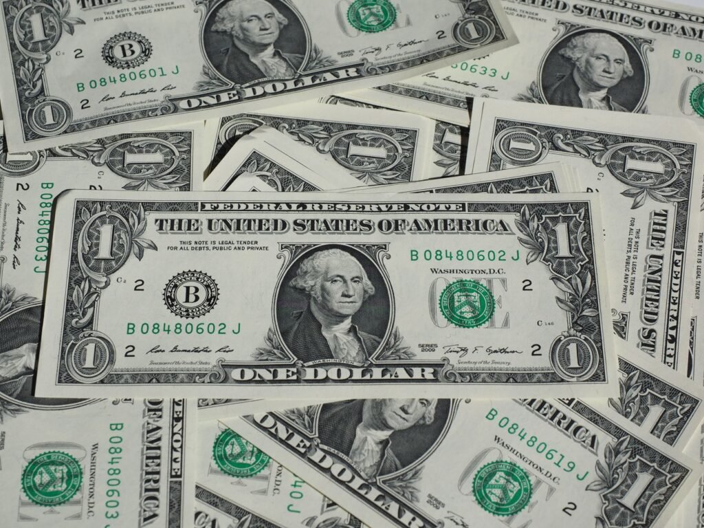Uma imagem detalhada de um monte de notas de um dólar dos EUA, destacando conceitos de moeda e finanças.