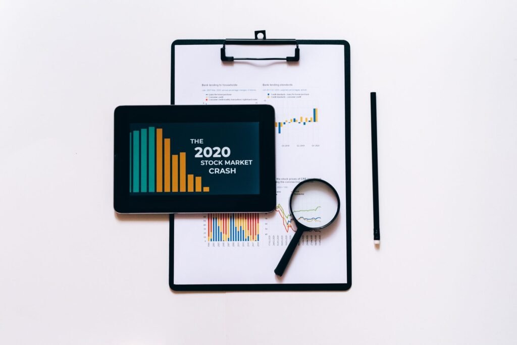 Tablet, lupa e prancheta para análise do mercado financeiro.