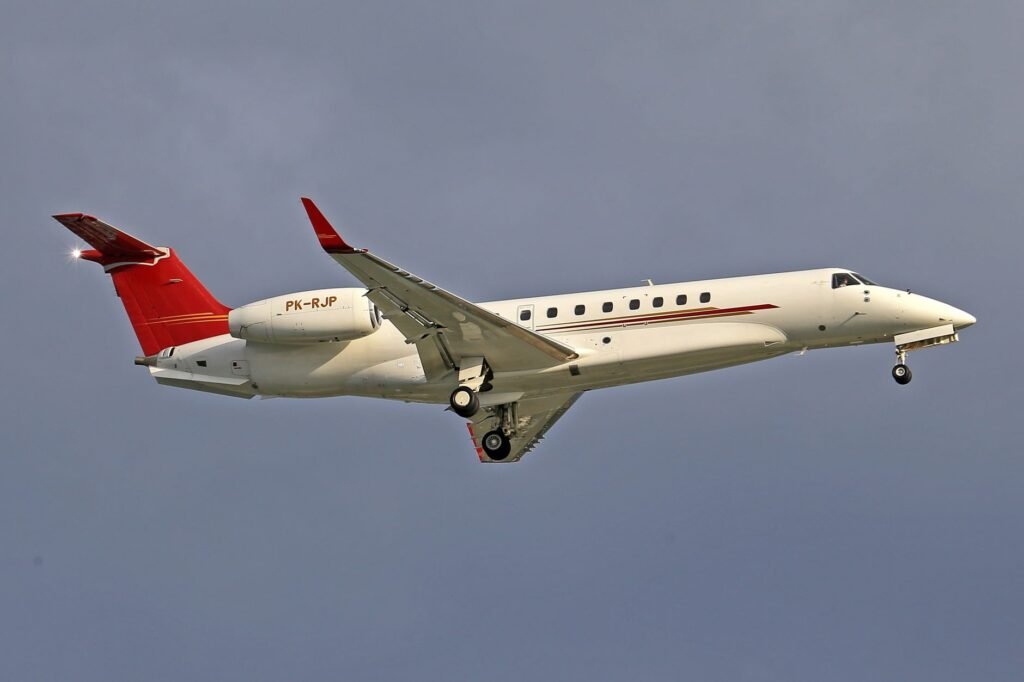 Vista aproximada de um jato particular em voo contra um céu claro, capturando a elegância da aviação.