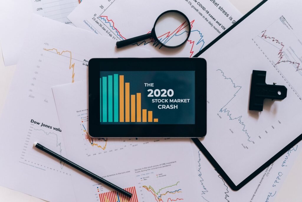 Visão de cima de tablet mostrando a queda do mercado de ações de 2020 com gráficos e papéis.