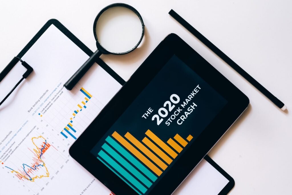 Lupa e tablet analisam dados do colapso do mercado de ações de 2020 com gráficos na prancheta.