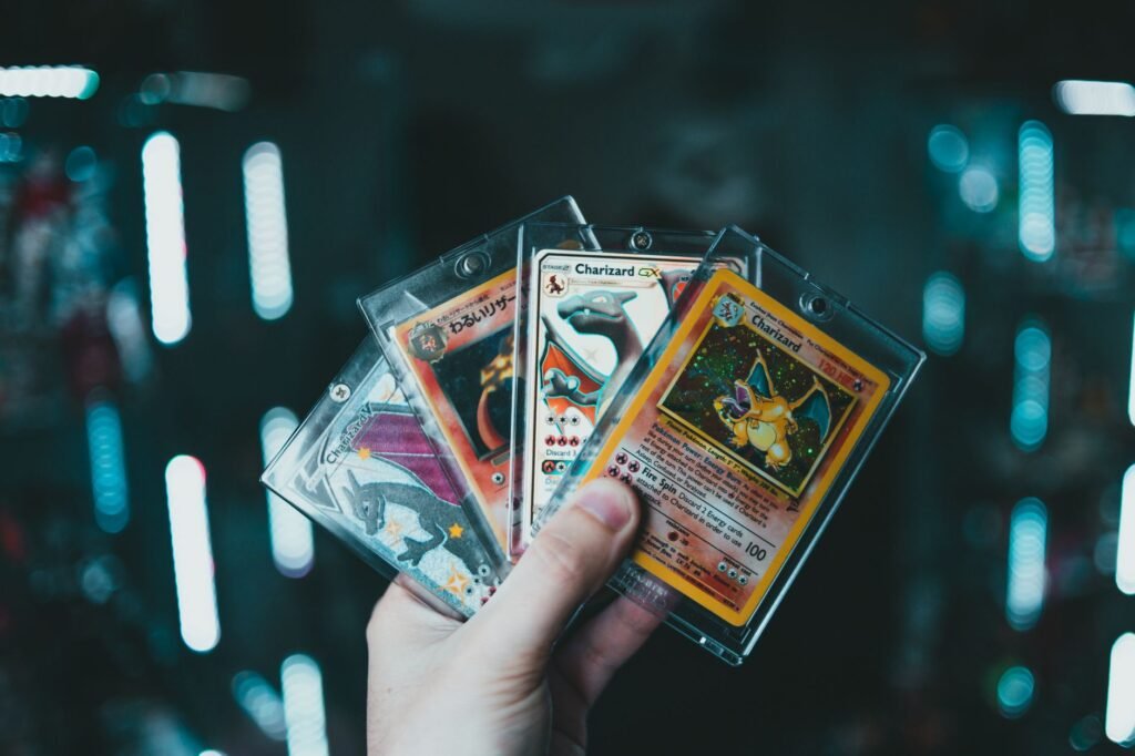 Uma mão segura cartas colecionáveis de Charizard Pokémon com um fundo bokeh desfocado. Perfeito para entusiastas de cartas colecionáveis.