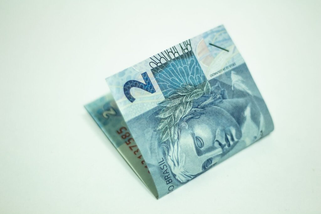 Imagem detalhada de uma nota de 2 reais dobrada em um fundo branco.
