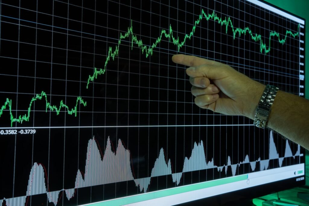 Gráfico que mostra a análise de dados financeiros com uma mão apontando para as tendências de mercado.